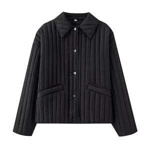 Detail of silver heart-shaped buttons on women's black quilted jacket with vertical stitching