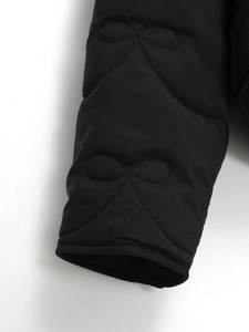 Detail of bow-shaped quilting on black water-resistant puffer jacket cuff