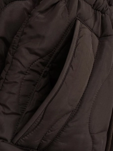 Detail of side pocket on dark brown quilted coat with wave stitching and matte finish