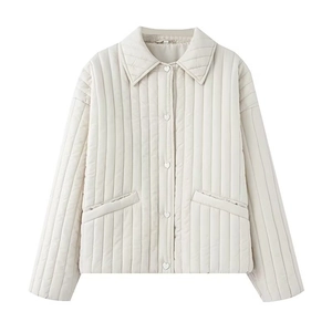 Detail of cream-white quilted jacket featuring unique heart-shaped buttons and vertical stitching