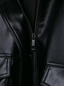 Detailansicht einer schwarzen Lederjacke mit silbernem Reißverschluss und Steppnähten