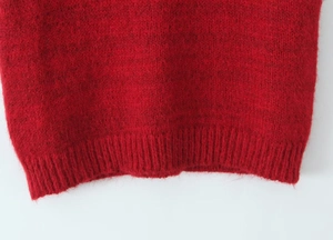 Detailed close-up of red mohair knit vest featuring ribbed hem and fuzzy texture
