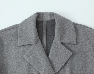 Close-up of lapel and collar structure on a premium grey wool blend coat for women