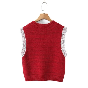 Close-up of red knit vest featuring white lace bow trim on the armhole and round neck