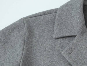 Close-up of precise shoulder stitching and premium texture on a grey wool blend coat