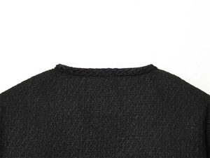Close-up of neckline showing black tweed fabric texture and woven braided trim detail