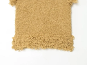Détail macro du gilet en maille camel effet fourrure montrant la texture douce