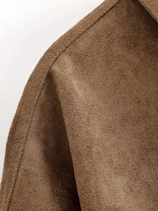 Close-up of brown suede jacket showing double stitching and premium fabric texture
