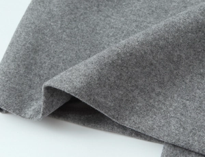 Detailed macro view of the grey wool blend fabric texture on long notched lapel coat
