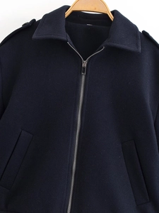 Close-up of the zipper closure and shoulder straps on this dark blue woolen jacket