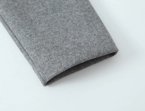 Detailed macro view of the grey wool coat cuff showing premium fabric texture and neat stitching