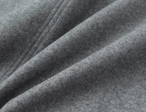 Close-up of dark grey wool blend fabric showing soft texture and double stitching