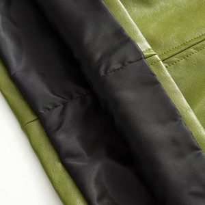 Macro shot of grass green lychee-textured leather jacket with premium stitching detail