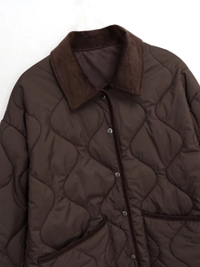 Detail of diamond quilted texture and corduroy collar on dark brown winter jacket