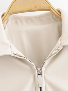 Detail of lapel collar and silver metal zipper on cream faux leather PU jacket