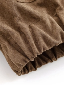 Detailed macro view of brown faux suede fabric with elastic ribbed cuff and stitching