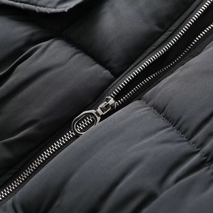 Gros plan de la fermeture éclair en argent et texture matelassée sur veste noire