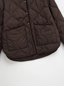 Detail of brown quilted jacket with gourd pattern stitching and metal snap buttons