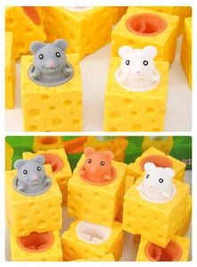 Detail of squeezing yellow cheese block toy with cute grey mouse popping out of it