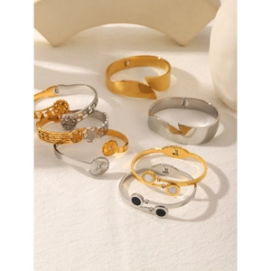 Detail of geometric stainless steel bracelets in gold and silver with hollowed stars