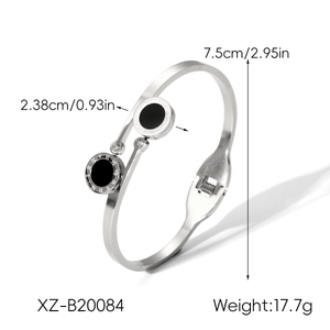 Detail view of steel bangle featuring black circular charms with Roman numeral engravings