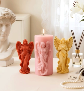 Detailed view of angel shaped candles with intricate relief carvings in an artistic setting