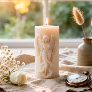Kneeling angel 3D relief scented candle on linen fabric with a warm glowing flame