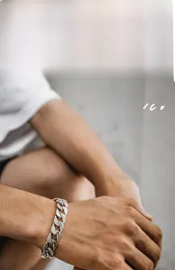 Close-up of a chunky 925 sterling silver Cuban link bracelet on a male model's wrist