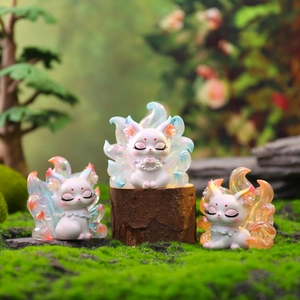 Drie lichtgevende Nine-Tailed Fox figuren met gradiënt staarten op een houten basis