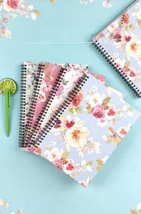 Detailed close-up of colorful floral spiral A5 notebooks with black metal coils