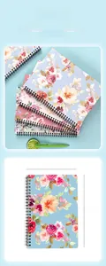 Detailed view of A5 floral notebook featuring durable black double spiral coil binding