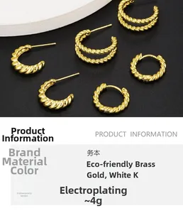 Detailed view of gold twisted C-shape hoop earrings and cuff on black matte background