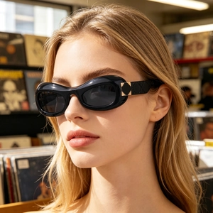 Detail of black oval sunglasses featuring quilted pattern temples and gold diamond accents