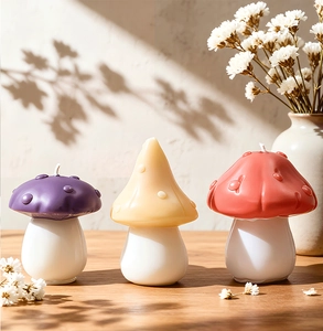 Detailed view of three colorful handmade mushroom scented candles on a wooden surface