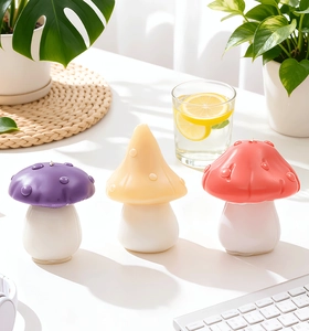Detailed view of three colorful mushroom candles in purple, yellow, and coral pink