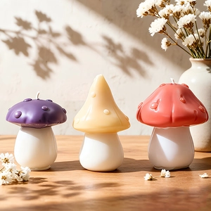 Three creative mushroom candles in purple, yellow, and red on a rustic wooden table
