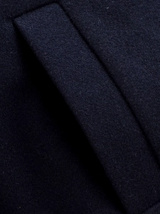 Detailed macro view of dark navy wool blend fabric and seamless inset pocket craftsmanship