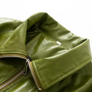 Close-up of olive green PU leather jacket with stylish collar and silver metal zipper