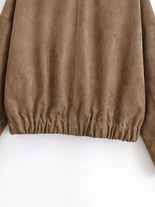 Detail of elastic hem on a dark brown suede jacket showing high-quality fabric texture