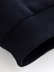 Close-up detail of dark blue ribbed cuffs and cotton jersey fabric on the jacket sleeve
