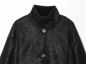 Vue détaillée d'une veste en similicuir noir avec col montant et gros boutons ronds