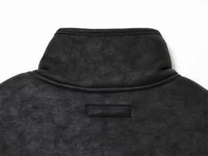 Détail de la veste en cuir noir mat montrant les coutures de qualité sur le col montant