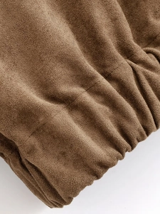 Detail shot of brown suede jacket showing elastic cuff texture and precise stitching