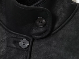Détails d'une veste en cuir noir montrant le col montant, les coutures et la doublure polaire