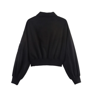 Back view of a black cropped jacket with drop shoulders and ribbed elastic cuffs and hem