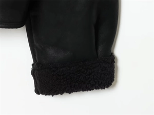 Détail de la manchette d'une veste en similicuir noir avec doublure en sherpa doux