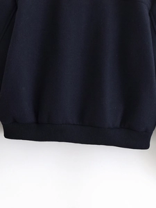Close-up of the ribbed hem and precise stitching on this dark navy zip-up jacket