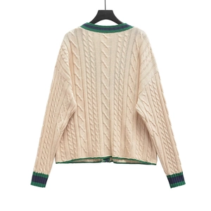 Detailed back view of beige cable-knit cardigan with green and navy striped cuffs