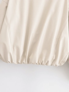 Detailed macro view of the elastic hem and quilted seams on this cream PU leather jacket
