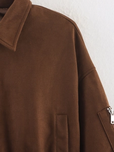 Detailed view of dark brown suede jacket featuring a collar and sleeve zipper pocket